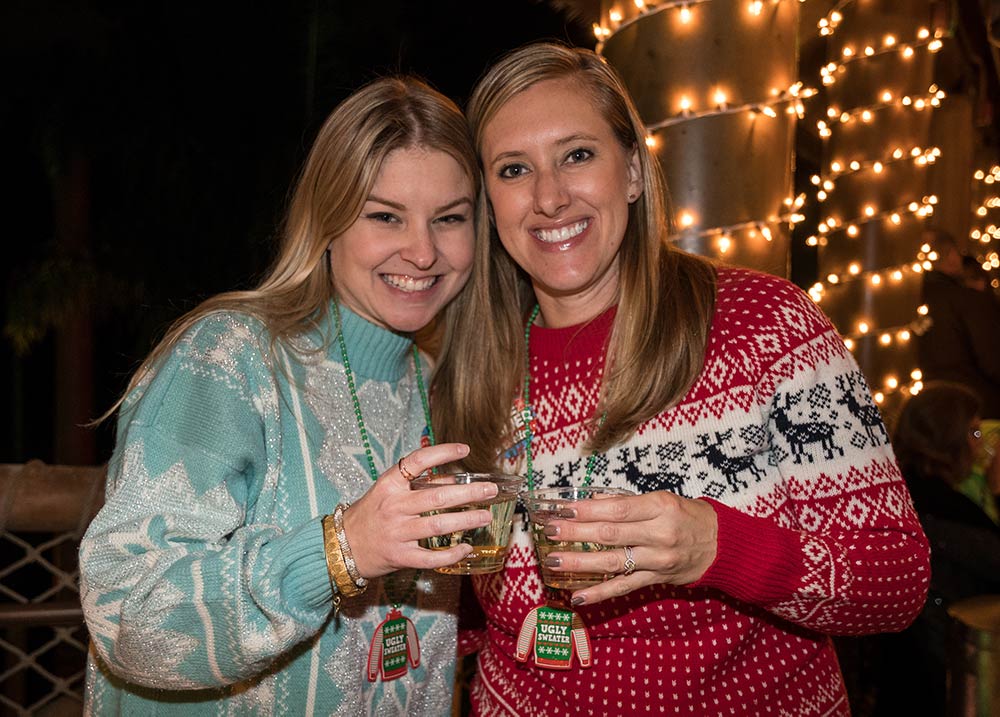 Two people enjoying drinks in holiday sweaters