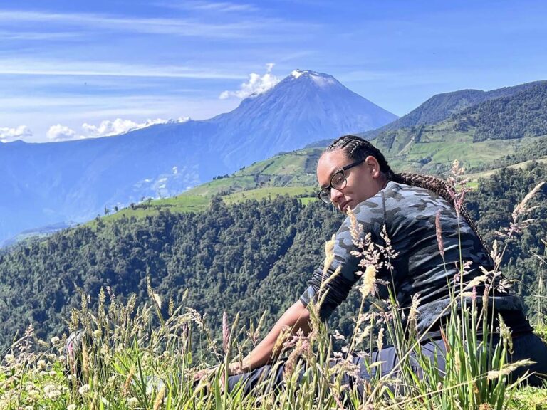 Field Notes: Ecuador with Dr. Jordan Davis-Powell Dr. Davis-Powell sits in a mountain field with a volcano in the background