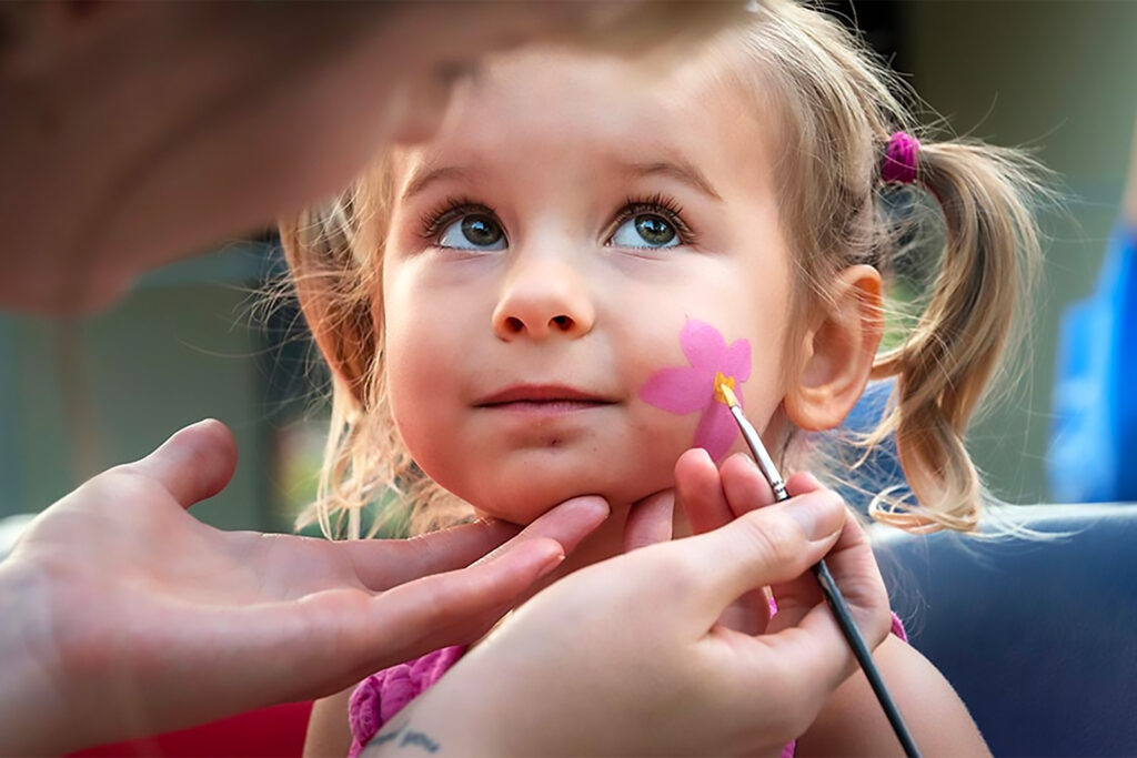 Child face painting at a Zoo member event