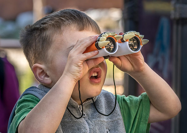 Boy with binoculars enjoy Bird Watching at the LA Zoo.
