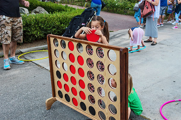 A girl plays Connect 4 at the Zoo Block Party