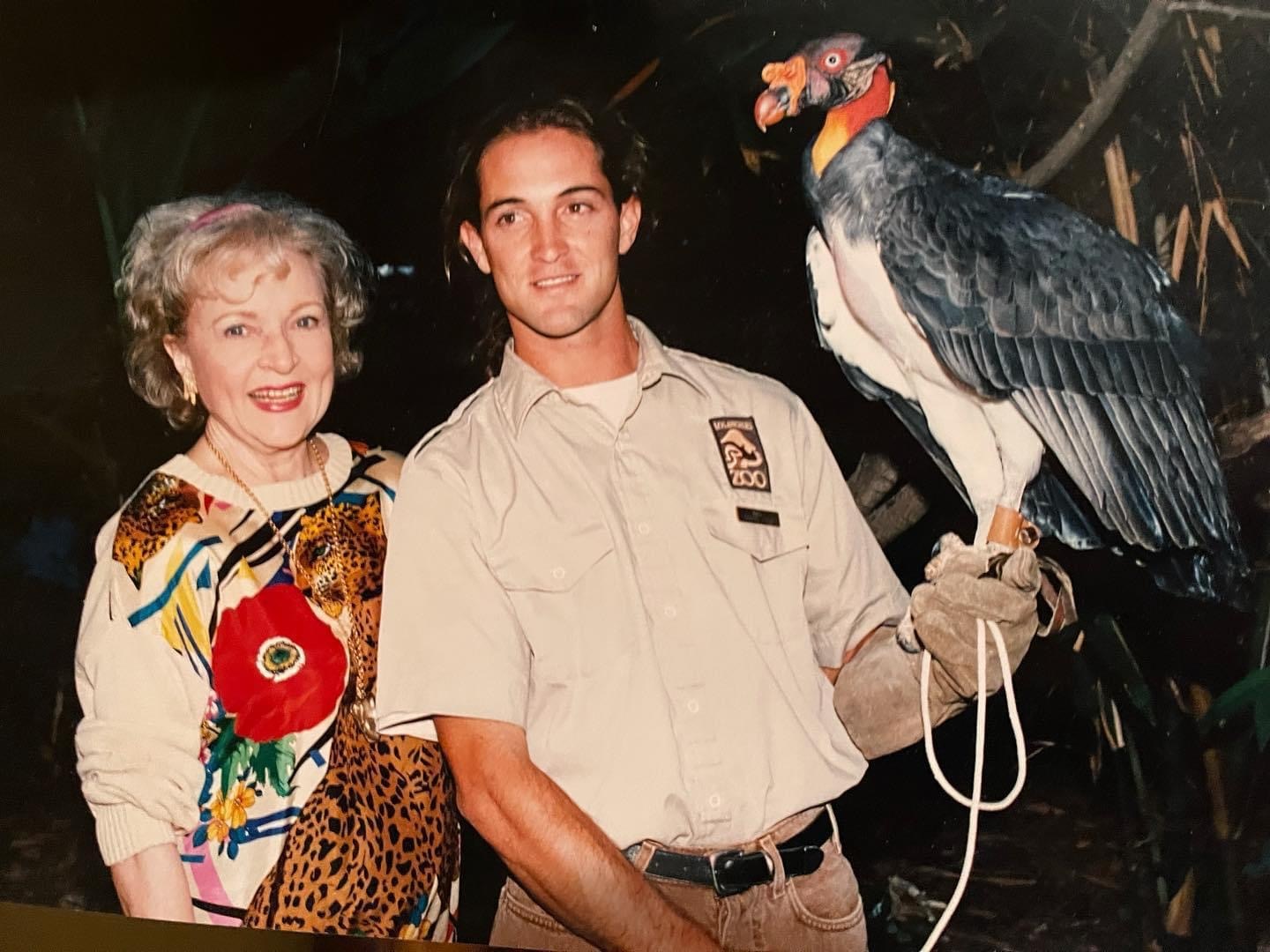 Mike, dressed in animal keeper khakis, offers his heavily gloved arm as a perch for a king vulture while actress Betty White grins by his side.