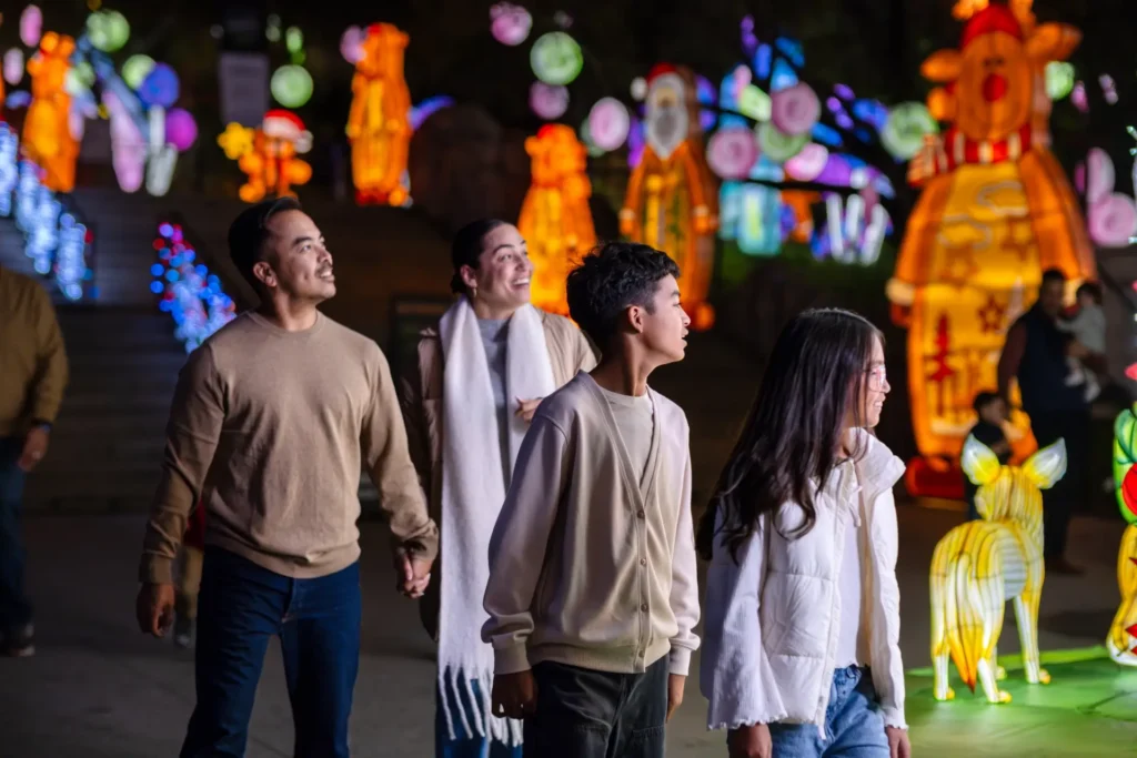 family walking through zoo light installations